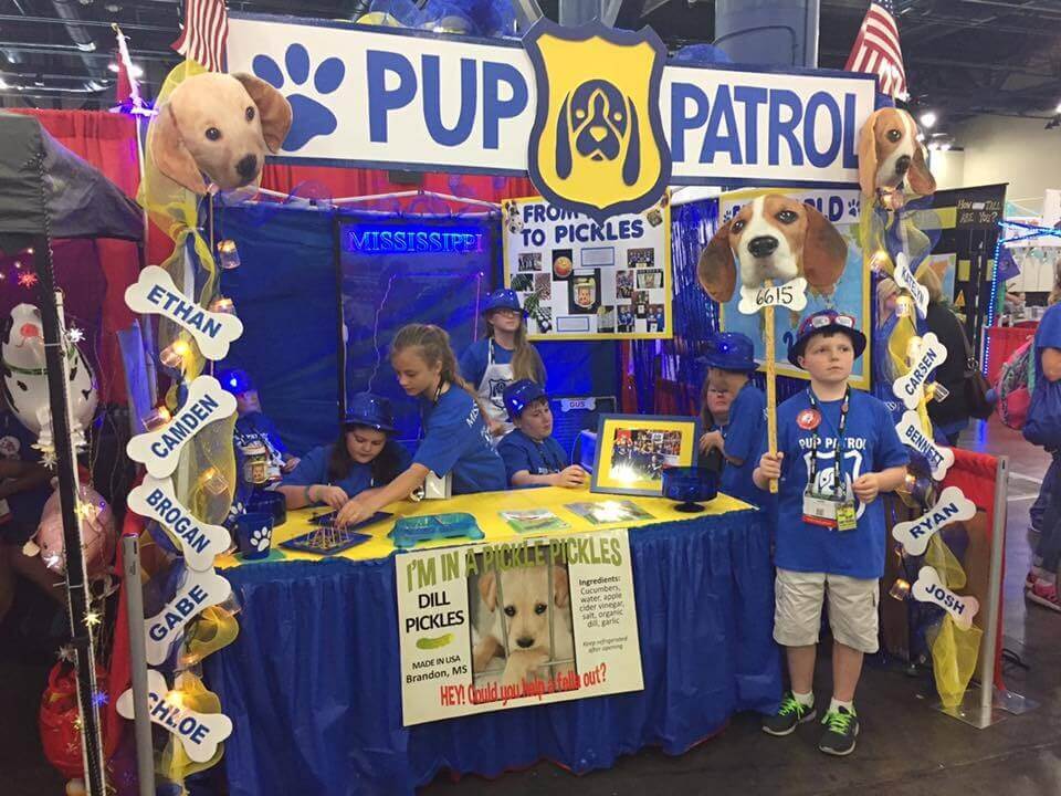 Students standing at a table with a "Pup Patrol" sign