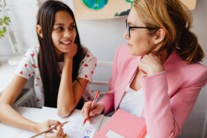 Student and adult writing together