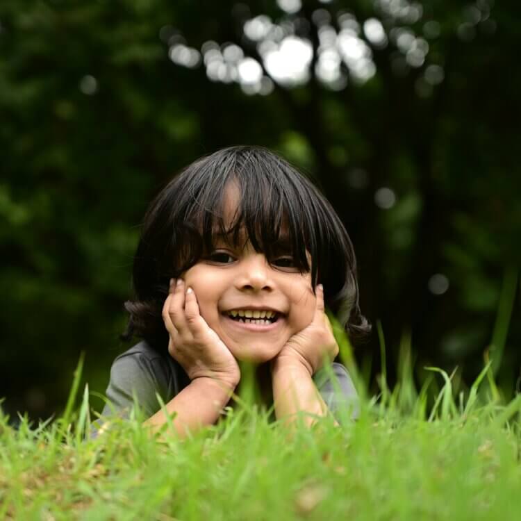 Boy smiling while laying in grass