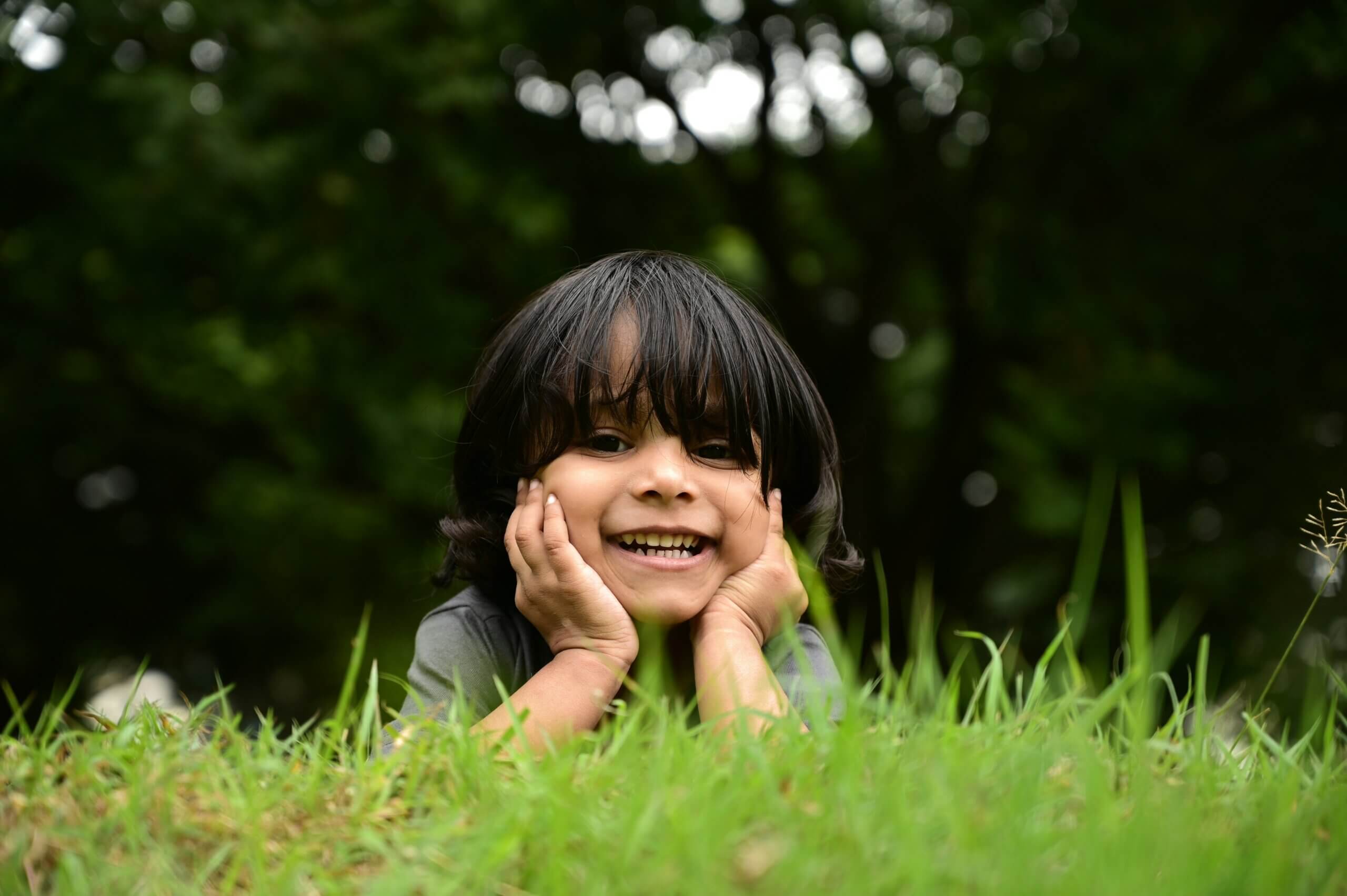 Boy smiling while laying in grass