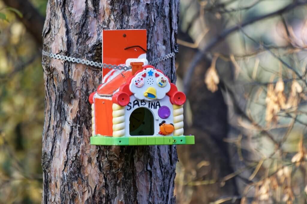A child's birdhouse hanging from a tree