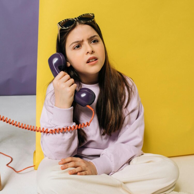 confused looking kid on the telephone