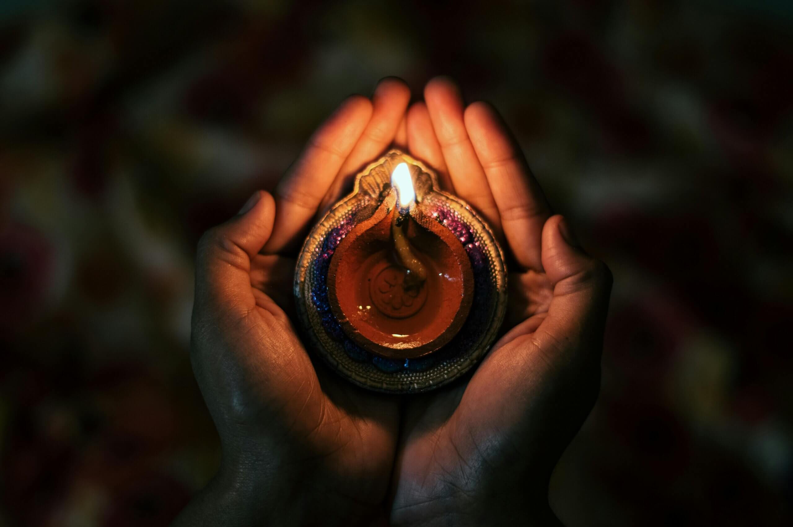 person with candle in hands - Diawli