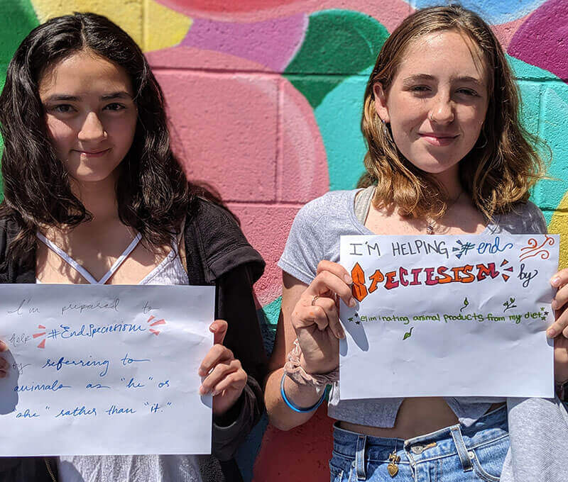 students holding signs to help end speciesism
