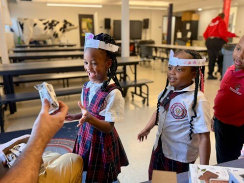 Students smile as they receive vegan ice cream sandwiches