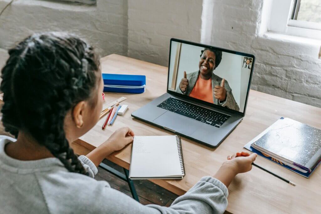 student having a video chat with her teacher online on laptop