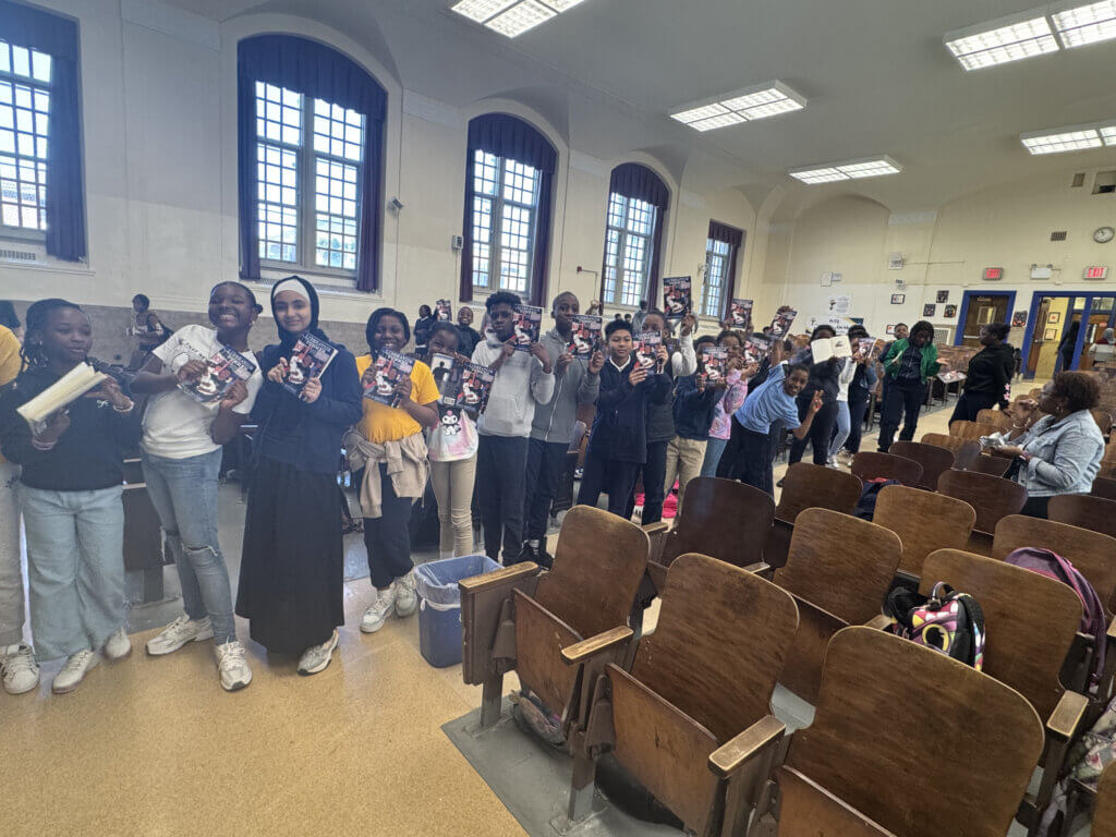 Happy students show off their signed copies of Liberation Summer by Stewart Mitchell at a Meet the Author event at PS37Q