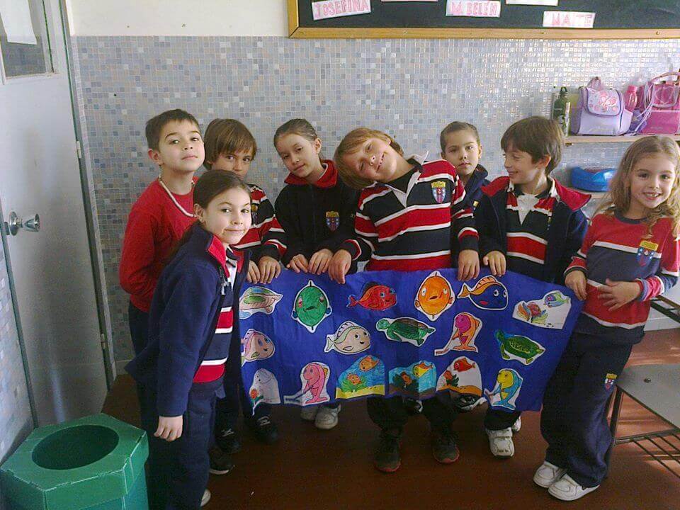 Kids holding fish poster in classroom