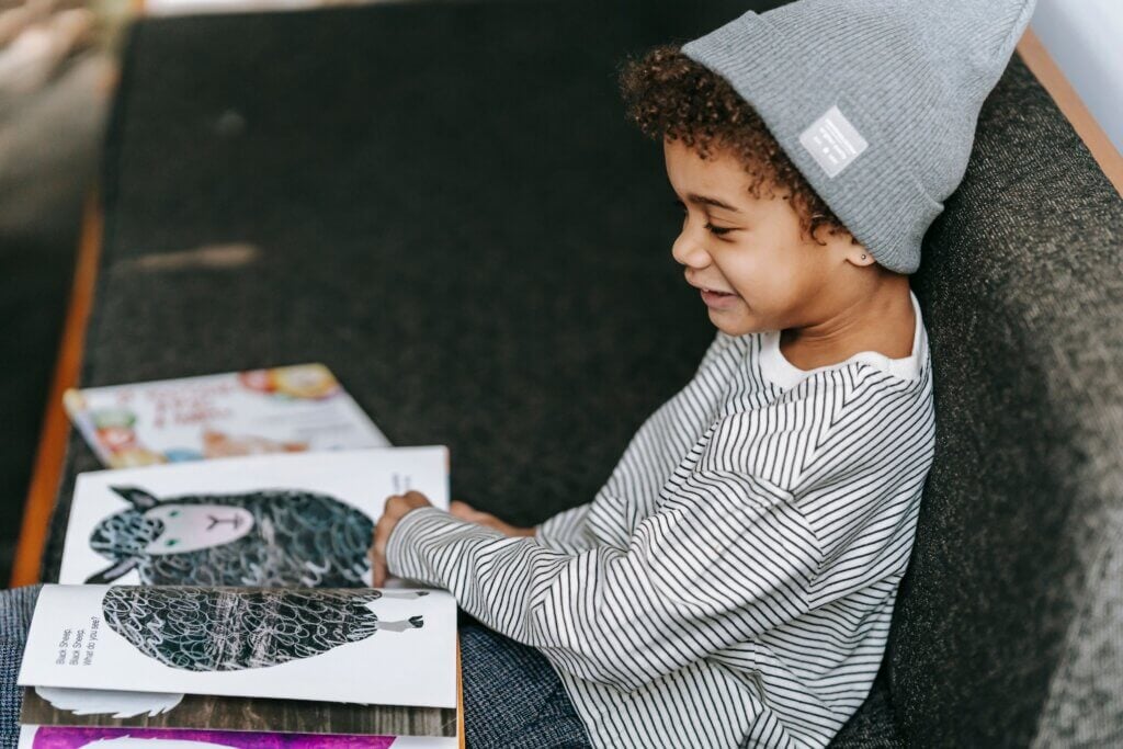 A smiling student is reading a book about animals.